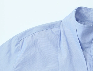 Detail shot of the neckline and shoulder seams on this light blue cotton bow shirt