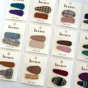 Detail showing assorted fabric textures of handmade bow hair clips on display cards