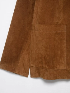 Close-up of brown suede jacket detail showing stitching and fine leather texture