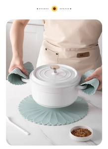 Mint green heat-resistant silicone oven mitts and matching floral placemat in kitchen use