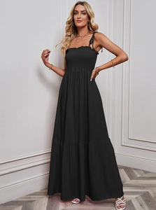 Detail of black strapless maxi dress with ruffled smocked bodice and flowing skirt