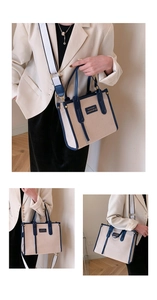 Detail of beige canvas tote with blue leather trim and wide adjustable shoulder strap