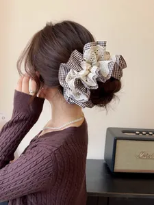 Detail of retro houndstooth and lace hair scrunchie shown on a ponytail hairstyle