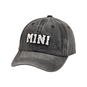 Dettaglio del ricamo 3D MINI bianco su un cappellino da baseball in cotone grigio