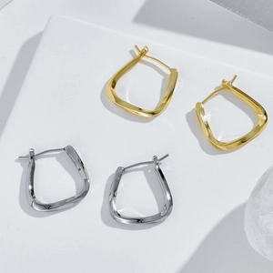 Close-up of twisted 14k gold and silver earrings with micro-pave cubic zirconia crystals