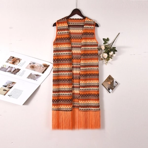 Détail du cardigan en maille avec motifs géométriques et fines franges au bas du vêtement