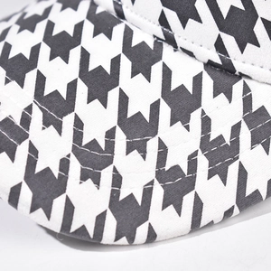Macro shot of black and white houndstooth pattern fabric and stitching on baseball cap
