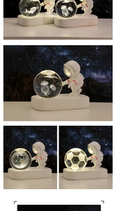 Macro shot of 3D laser engraved whale inside a glowing crystal ball held by astronaut