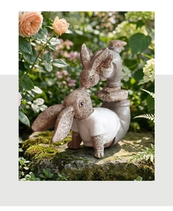 Close-up of resin rabbit statues with realistic fur textures in a lush garden setting