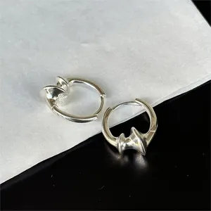 Macro shot of S925 sterling silver hoop earrings with a geometric deconstructed design