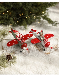 Detailed close-up of iron Santa and reindeer airplane ornaments on a snowy wood base