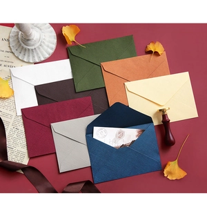 Close-up of vintage linen texture envelopes with wax seals and decorative gingko leaves
