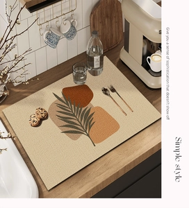 Detail of absorbent faux linen dish mat with leaf pattern on a kitchen countertop