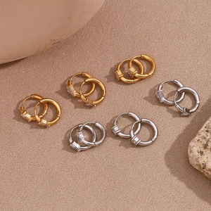 Macro view of geometric gold and silver hoop earrings with clear cubic zirconia stones