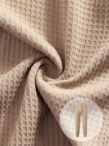 Close-up of khaki waffle texture fabric with drawstring waistband details on men's pants