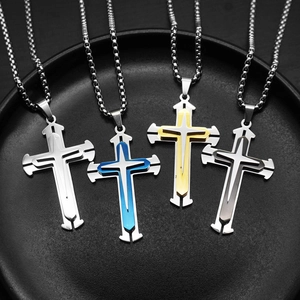 Close-up of triple-layered cross necklaces in silver, gold and black stainless steel finish