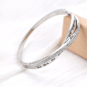 Vue détaillée du bracelet argenté torsadé avec chiffres romains et strass pavés