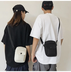 Minimalist canvas crossbody phone bag shown on models in cream and black color options