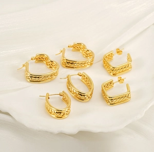 Détail de boucles d'oreilles dorées à texture épi en formes cœur, ovale et carrée