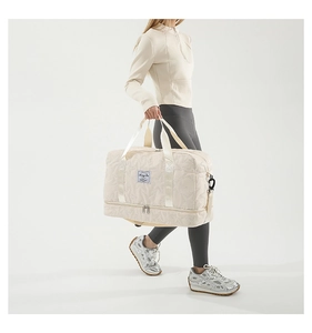Detail view of large beige quilted fitness bag with separate shoe compartment