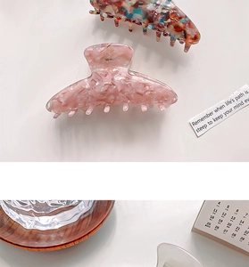 Detail of small leopard print acetate claw clips with mosaic pattern on white background