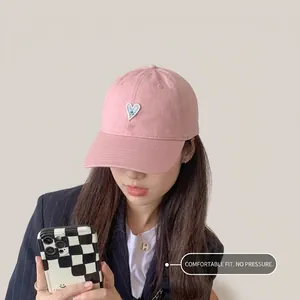 Detalle de gorra de algodón rosa con parche de corazón para playa y ciclismo femenino