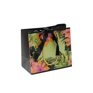 Tropical floral print gift bag with black satin bow and golden rope handles