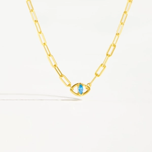 Macro shot of gold paperclip chain necklace with a blue marquise-cut gemstone pendant