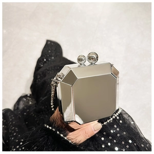 Close-up of a silver mirror acrylic clutch bag with a geometric octagonal faceted design