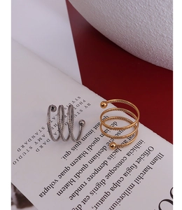 Detail of twisted spiral rings in gold and silver finish with ball ends on a card