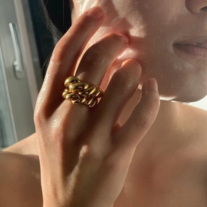 Minimalist double-layered braided rope twist ring in gold finish on a hand