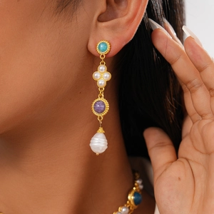 Macro detail of vintage gold drop earrings with turquoise, purple stones and pearls