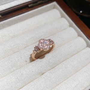 Macro shot of rose gold four-leaf clover ring with pink enamel and sparkling zircon stones