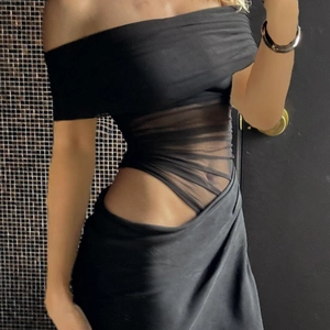 Detailed view of the black off-shoulder dress featuring waist cut-out with sheer mesh fabric