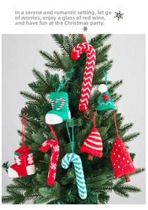 Detailed view of hand-knitted Christmas ornaments like candy canes and stockings on a tree