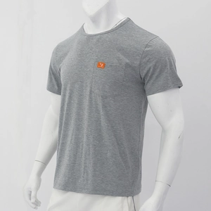 Detailed view of grey short sleeve T-shirt with chest pocket and small orange logo tag