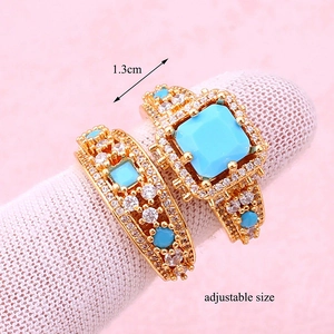 Macro detail of adjustable gold ring set with turquoise stones and size annotation