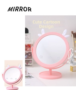 Pink desktop makeup mirror with cute ears and cat whiskers design on a vanity desk