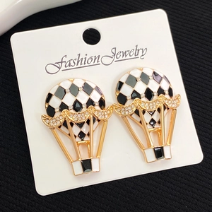 Vue détaillée des boucles d'oreilles montgolfière avec émail à damier noir et blanc et or