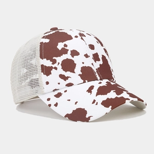 Dettaglio cappello trucker con stampa mucca, rete bianca e visiera curva per la protezione