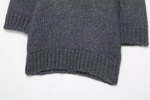 Close-up of thick dark grey knit fabric with ribbed hem and sleeve cuff details