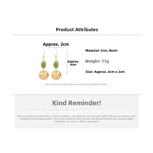 Détail des boucles d'oreilles sphère évidée avec résine verte et tiges en argent