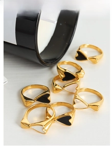 Flat lay of 18K gold plated heart rings with black and white enamel inlays