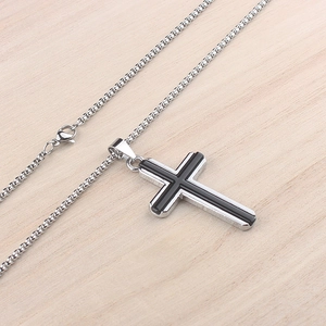 Détail de la chaîne vénitienne en argent et pendentif croix bicolore sur fond de bois