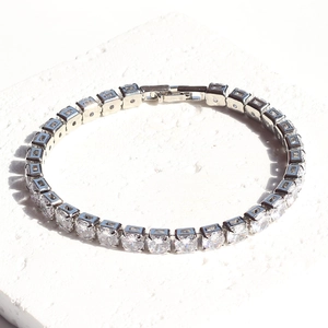 Detailed view of silver square-cut zircon tennis bracelet with 5mm stones on white stone