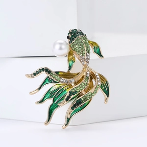 Dettaglio della spilla a forma di pesce con smalto verde, strass e una perla bianca pura