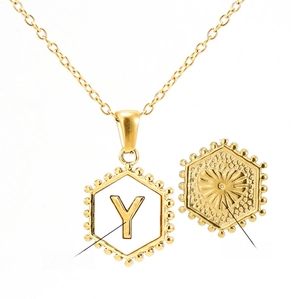 Detail of 18K gold hexagonal pendant showing letter Y and heart texture on the reverse