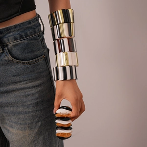 Close-up of geometric acrylic stretch bracelets featuring black and white stripe patterns