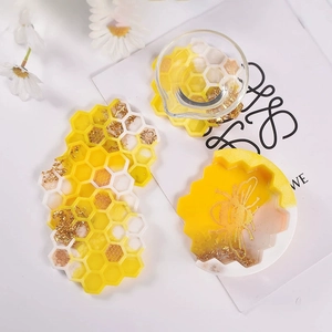 Vue détaillée des moules en silicone alvéolés jaunes avec motifs d'abeilles et flocons d'or