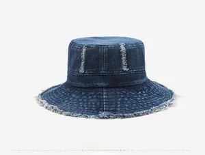 Close-up of distressed edges and ripped details on dark blue denim bucket hat